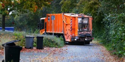 a garbage truck is parked on the side of the road