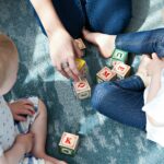 two toddler playing letter cubes