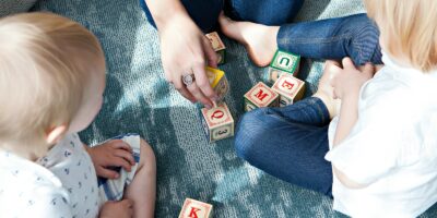 two toddler playing letter cubes