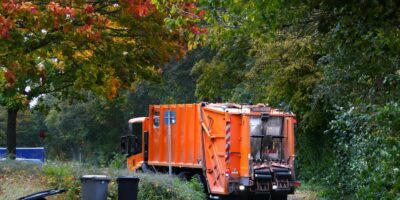 a garbage truck is parked on the side of the road